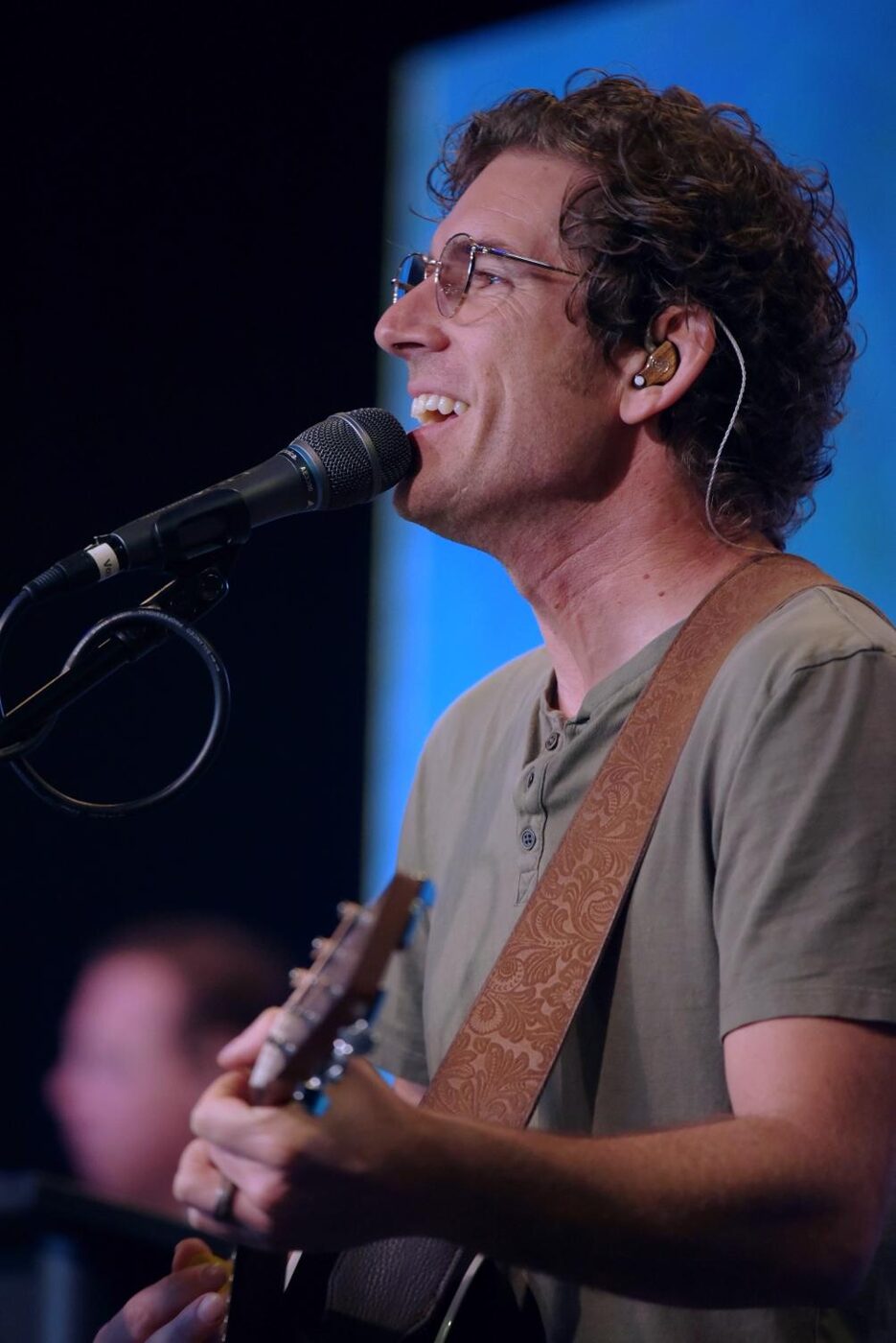 Michael Schirner singing and playing acoustic guitar on stage